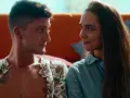 Para, która czuje się jak 3 metry nad niebem, siedzi blisko siebie na kanapie.
