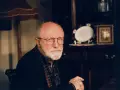 Portret starszego mężczyzny z siwą brodą i okularami. W tle widać meble i ozdobną zastawę. Wiele osób zastanawia się, jak zmarł Henryk Machalica.