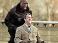 Dwóch mężczyzn, jeden na wózku, śmieje się radośnie. Film "Nietykalni gdzie obejrzeć" to wzruszająca historia przyjaźni.