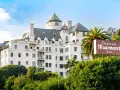 Chateau Marmont, miejsce, gdzie może mieszkać Keanu Reeves, to biały hotel z zielonym dachem i palmami.