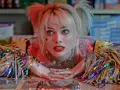 Harley Quinn z filmu "Ptaki Nocy" z błyszczącymi wstążkami i makijażem.