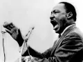 Martin Luther King przemawia z pasją do mikrofonu, jego głos niesie nadzieję i wolność.