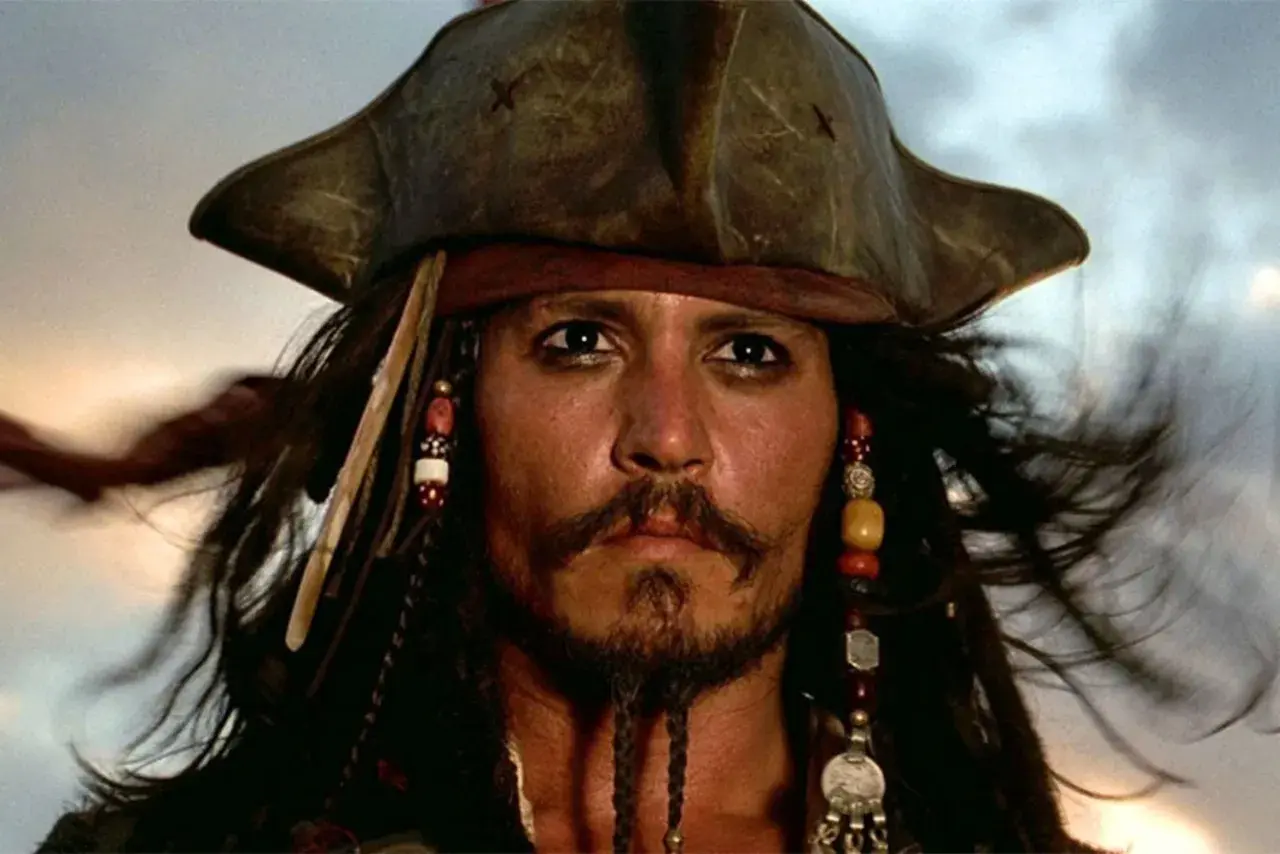 Kapitan Jack Sparrow w swoim charakterystycznym kapeluszu i z koralikami we włosach, gotowy na kolejną morską przygodę.