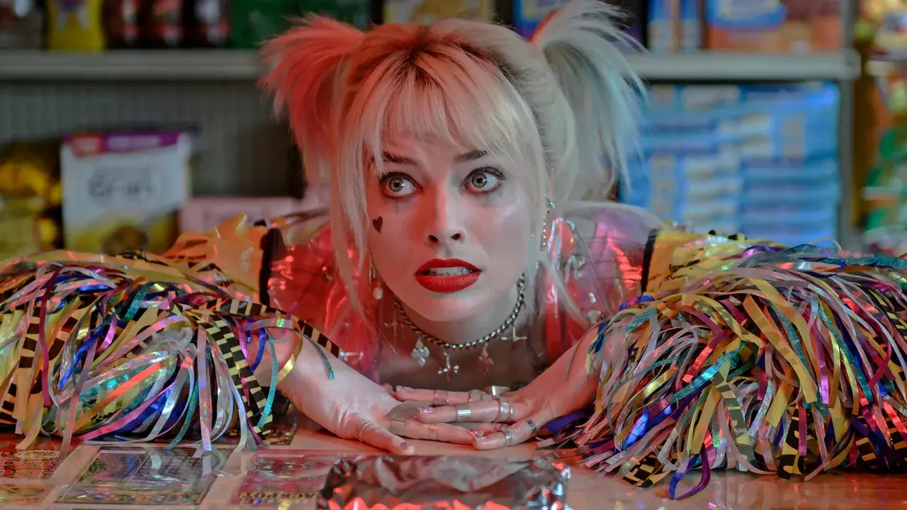 Harley Quinn z filmu "Ptaki Nocy" z błyszczącymi wstążkami i makijażem.