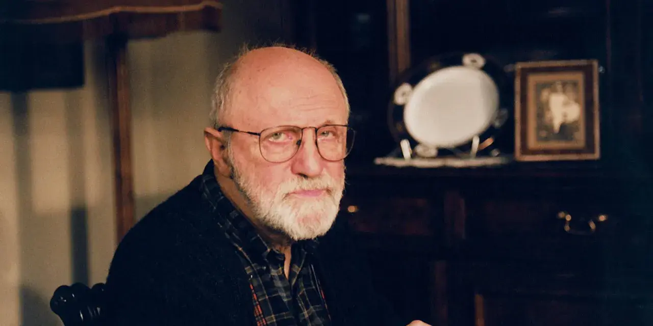 Portret starszego mężczyzny z siwą brodą i okularami. W tle widać meble i ozdobną zastawę. Wiele osób zastanawia się, jak zmarł Henryk Machalica.