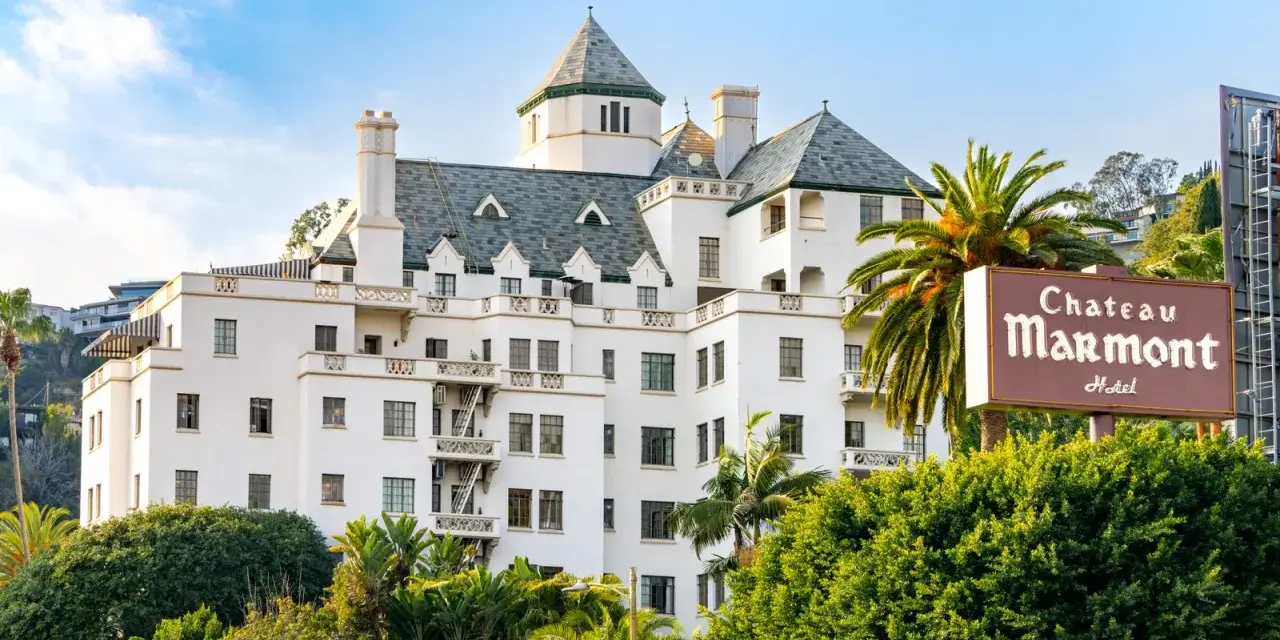 Chateau Marmont, miejsce, gdzie może mieszkać Keanu Reeves, to biały hotel z zielonym dachem i palmami.
