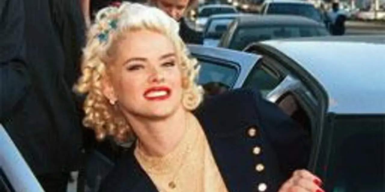 Anna Nicole Smith, z burzą blond loków i czerwoną szminką, wysiada z samochodu.