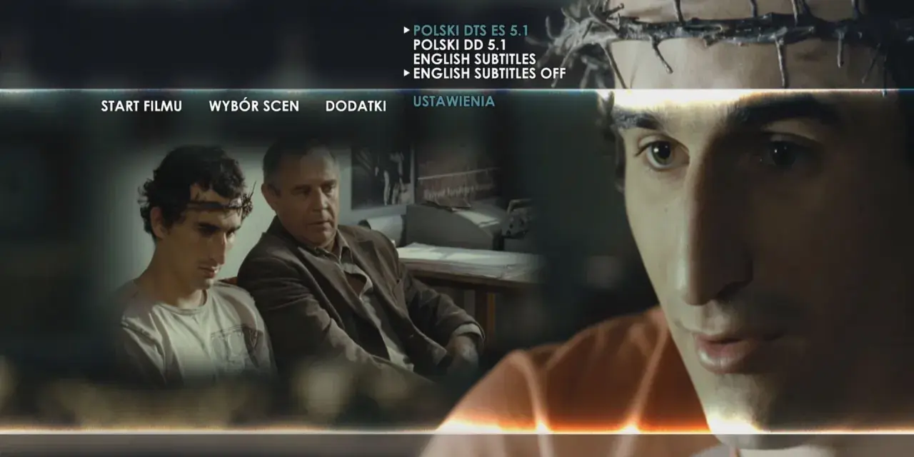 Mężczyzna z koroną cierniową na głowie, jakby wszyscy jesteśmy chrystusami, siedzi obok starszego mężczyzny. Menu filmu wyświetla opcje.