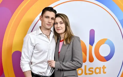 Małgorzata Patryn Gurłacz z partnerem pozują na tle kolorowego logo.