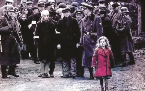 Dziewczynka w czerwonym płaszczu na tle sceny z filmu "Lista Schindlera".