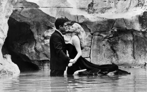 Para całuje się w wodzie, uosabiając la dolce vita.