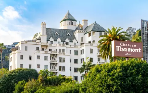 Chateau Marmont, miejsce, gdzie może mieszkać Keanu Reeves, to biały hotel z zielonym dachem i palmami.