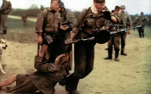 Żołnierz z karabinem ciągnie kobietę za włosy. Obok stoi pies. Idź i patrz, co się dzieje.