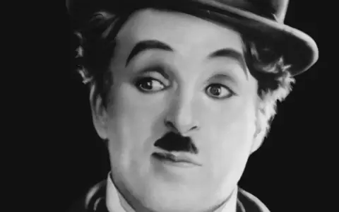 Charlie Chaplin w meloniku, z charakterystycznym wąsikiem, jakby opowiadał historie dla dzieci.