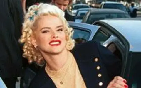 Anna Nicole Smith, z burzą blond loków i czerwoną szminką, wysiada z samochodu.