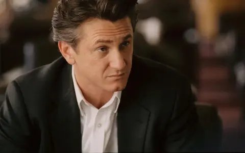Sean Penn w garniturze, zamyślony. Jego role w filmach zapadają w pamięć.