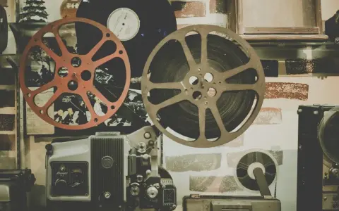 Stare klisze filmowe i projektor, gotowe do odtworzenia historii pełnej emocji i dramatów.