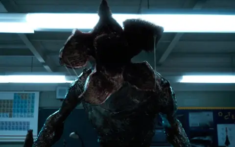 Potwór z serialu Stranger Things, Demogorgon, z otwartą paszczą w klasie.