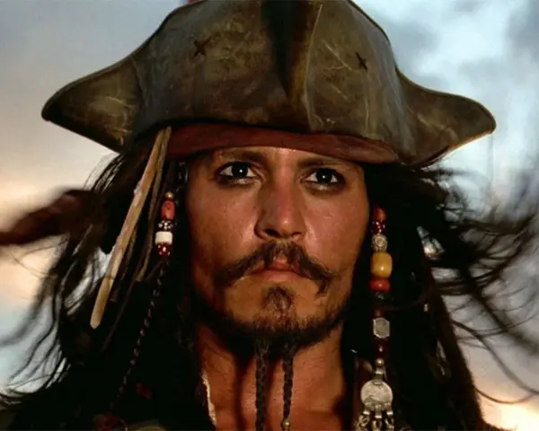 Kapitan Jack Sparrow w swoim charakterystycznym kapeluszu i z koralikami we włosach, gotowy na kolejną morską przygodę.