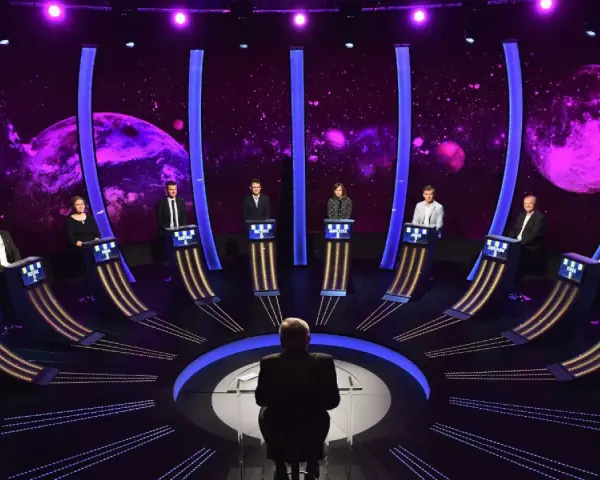 1 z 10. Uczestnicy teleturnieju stoją przy swoich stanowiskach na tle kosmicznej scenografii.