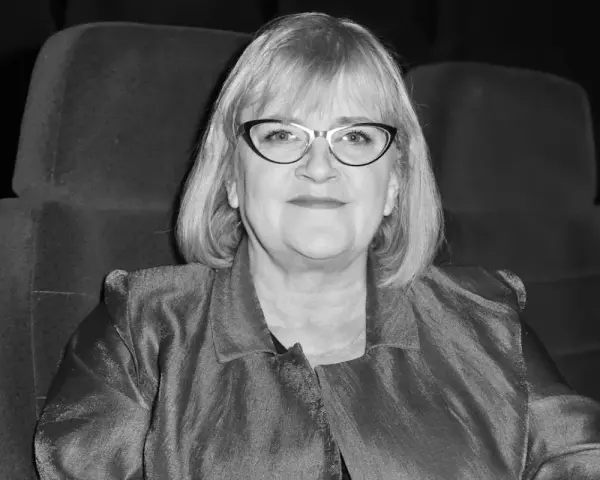 Marzena Kipiel w eleganckiej marynarce, siedząca w kinowym fotelu, emanuje spokojem i pewnością siebie. Jej spojrzenie sugeruje głębokie zanurzenie w sztuce.