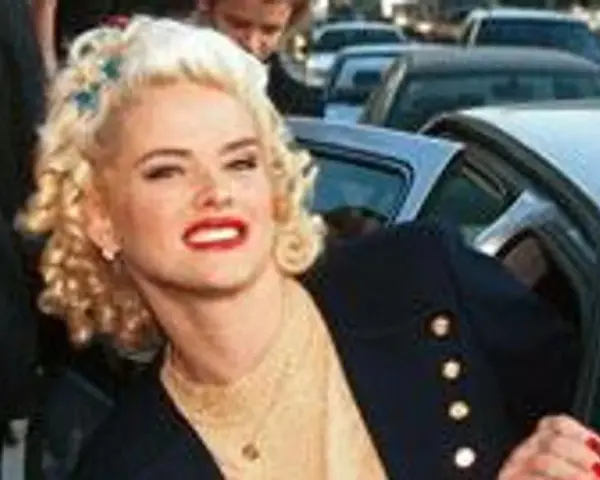Anna Nicole Smith, z burzą blond loków i czerwoną szminką, wysiada z samochodu.