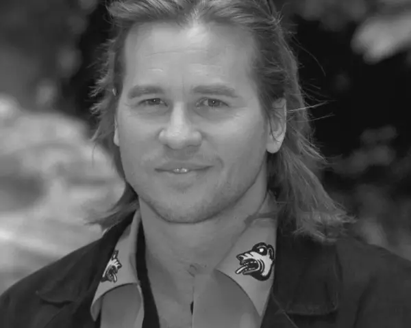 Val Kilmer, znany z wielu filmów, z charakterystycznym uśmiechem i długimi włosami.