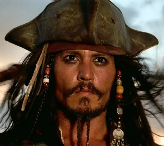Kapitan Jack Sparrow w swoim charakterystycznym kapeluszu i z koralikami we włosach, gotowy na kolejną morską przygodę.