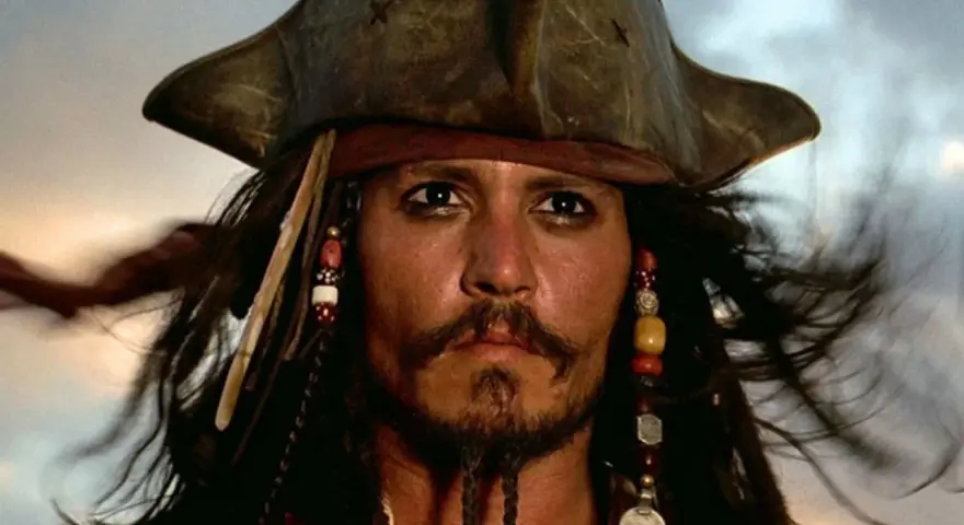Kapitan Jack Sparrow w swoim charakterystycznym kapeluszu i z koralikami we włosach, gotowy na kolejną morską przygodę.