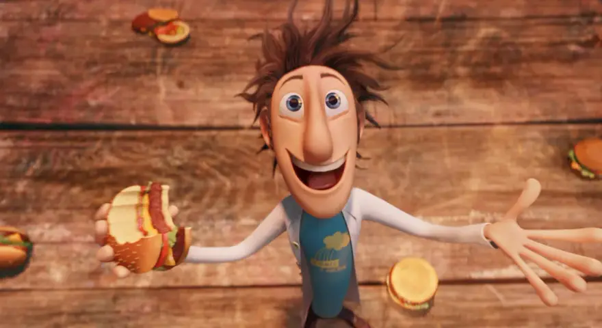 Flint Lockwood trzyma nadgryzionego hamburgera, podczas gdy wokół niego spadają klopsiki i inne zjawiska pogodowe.