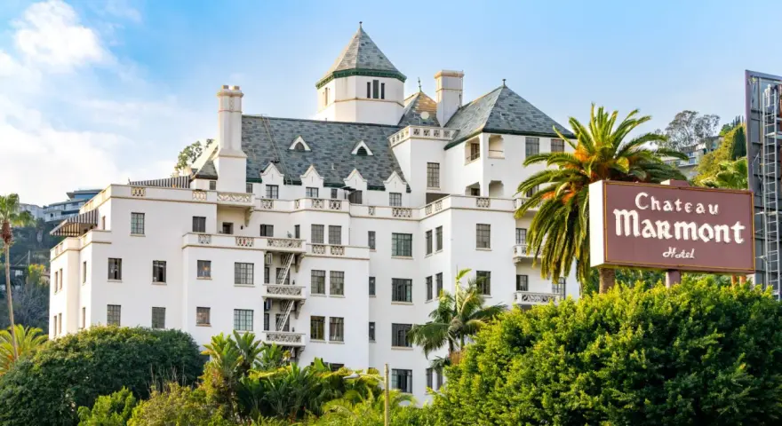 Chateau Marmont, miejsce, gdzie może mieszkać Keanu Reeves, to biały hotel z zielonym dachem i palmami.