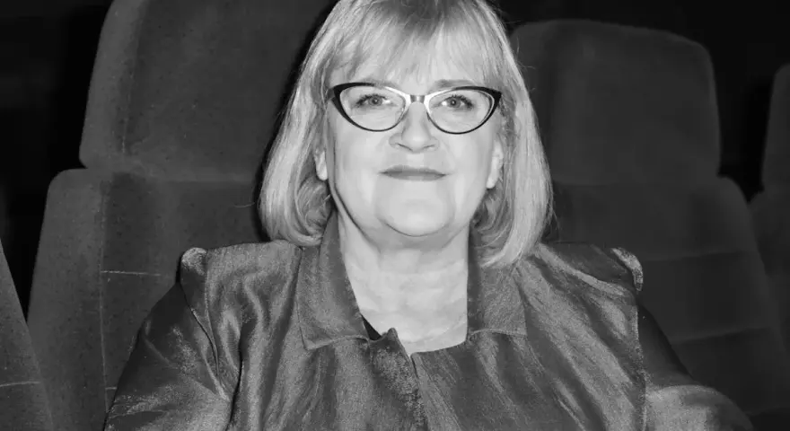 Marzena Kipiel w eleganckiej marynarce, siedząca w kinowym fotelu, emanuje spokojem i pewnością siebie. Jej spojrzenie sugeruje głębokie zanurzenie w sztuce.