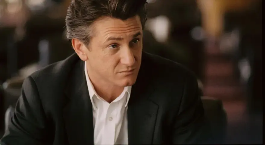 Sean Penn w garniturze, zamyślony. Jego role w filmach zapadają w pamięć.