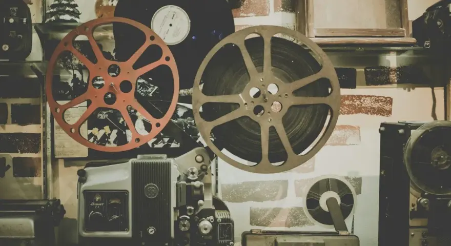 Stare klisze filmowe i projektor, gotowe do odtworzenia historii pełnej emocji i dramatów.
