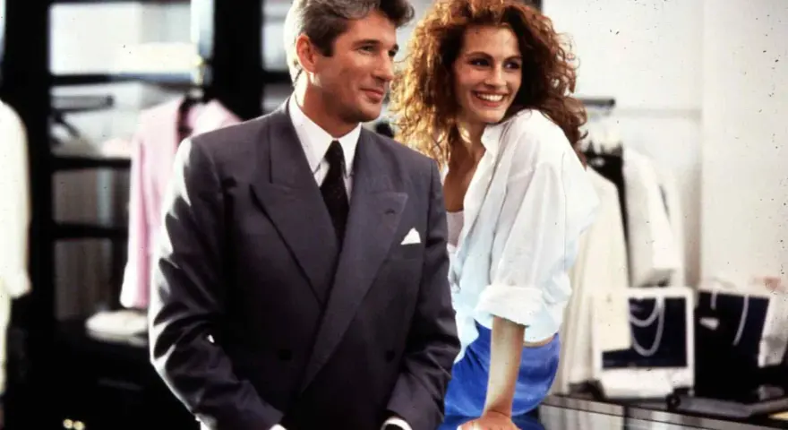 Elegancki mężczyzna w garniturze i uśmiechnięta, pretty woman w białej koszuli, stoją obok siebie w sklepie.