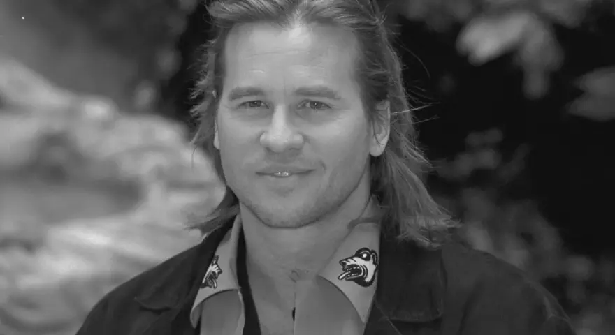Val Kilmer, znany z wielu filmów, z charakterystycznym uśmiechem i długimi włosami.