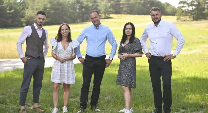 Uczestnicy programu "Rolnik szuka żony 10" pozują na tle zielonej łąki.