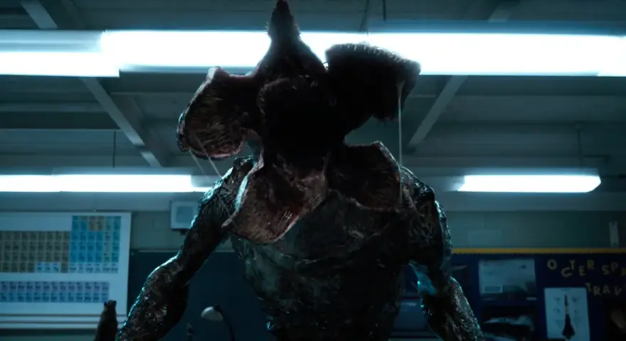 Potwór z serialu Stranger Things, Demogorgon, z otwartą paszczą w klasie.
