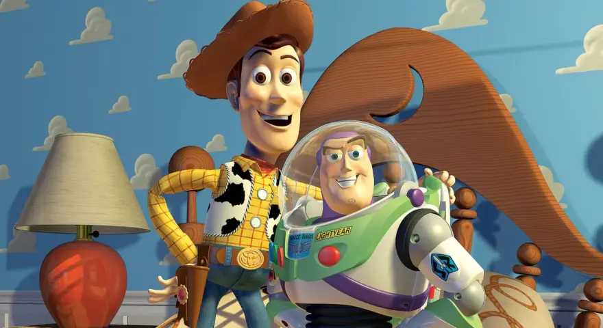 Woody i Buzz Lightyear, bohaterowie bajek z dzieciństwa, pozują na tle niebieskiej ściany z chmurkami.