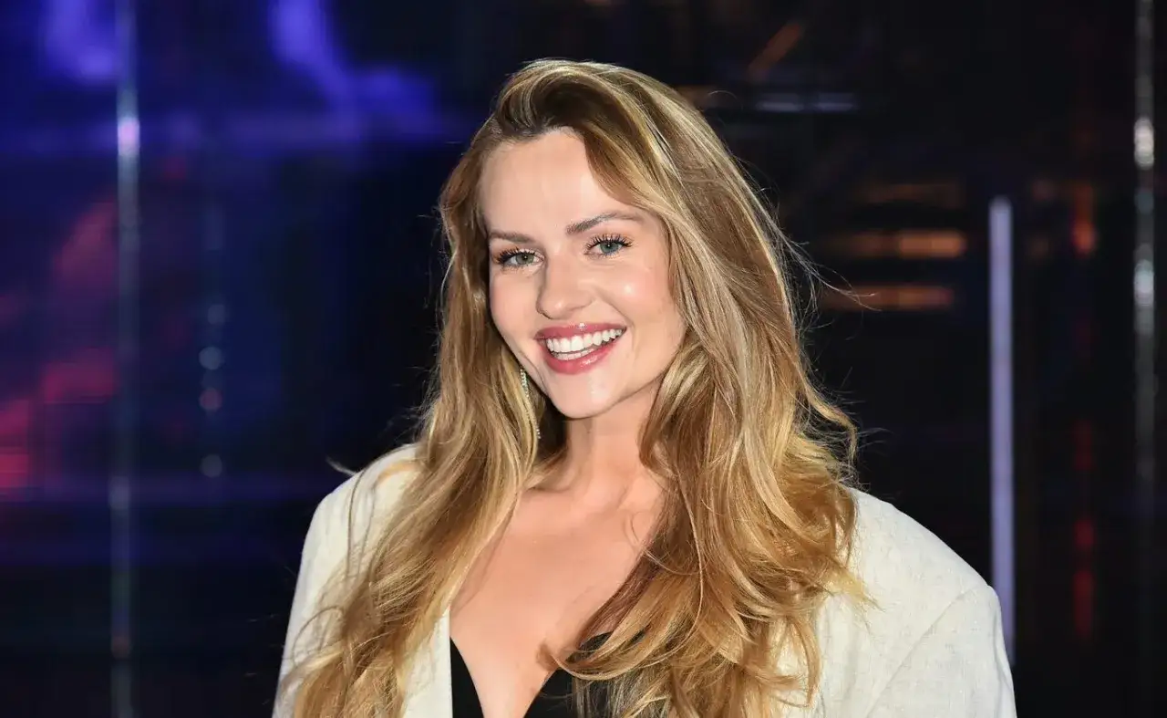 Uśmiechnięta Żaneta Rosińska, której wiek dodaje jej uroku, w jasnej marynarce i czarnym topie.