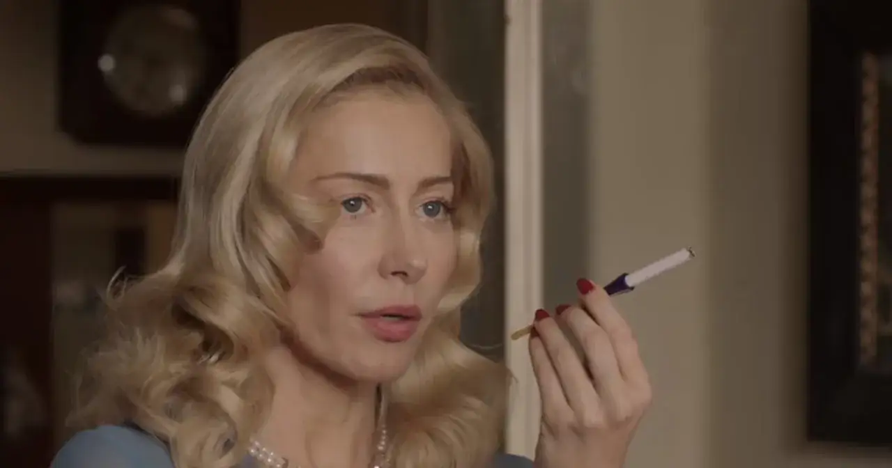 Blondynka z papierosem w dłoni, w stylu retro. Słyszy ciche 