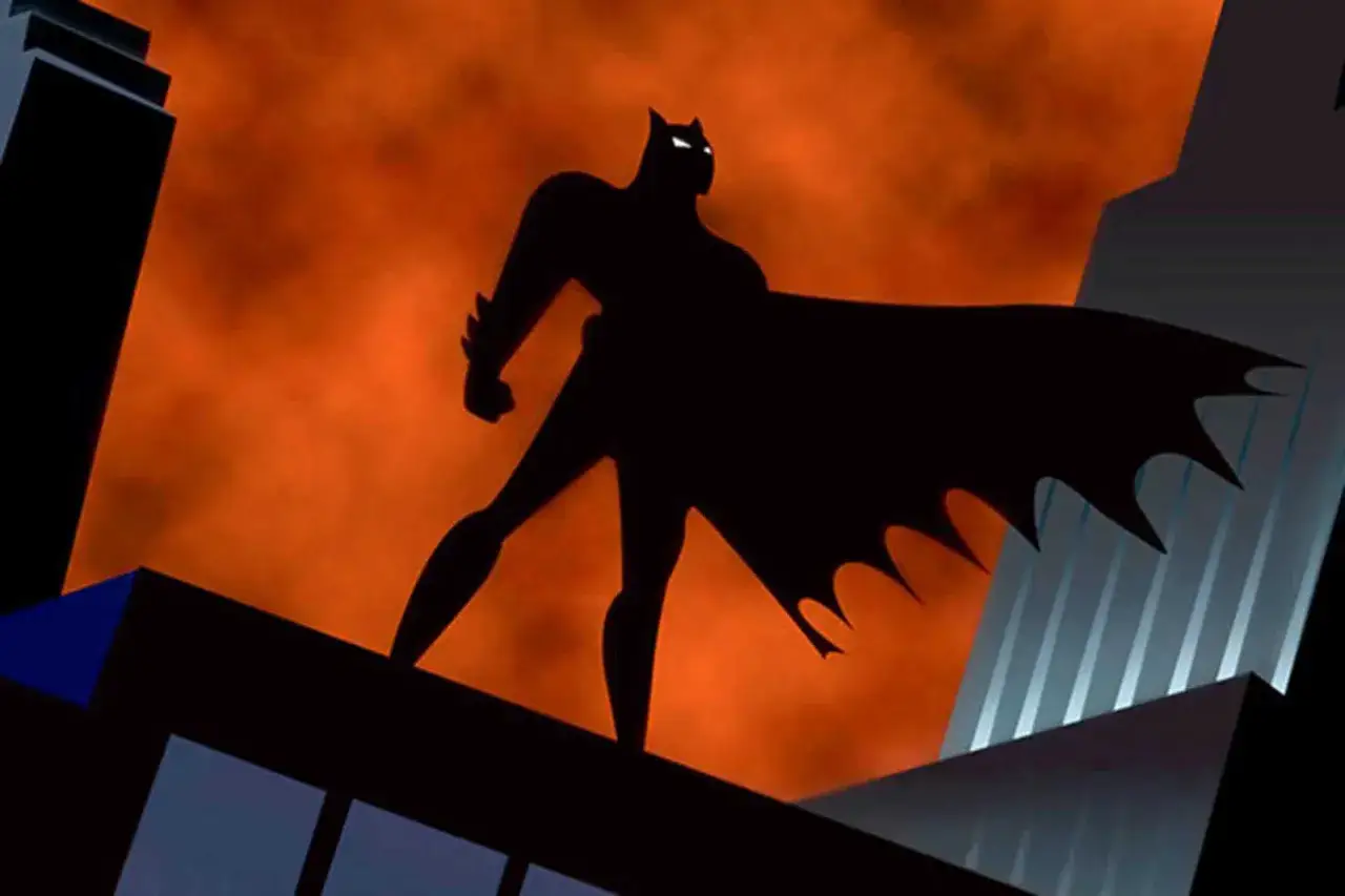 Czarny Batman na tle pomarańczowego nieba, stojący na dachu. To on, kto grał pierwszego Batmana w tej kultowej animacji.