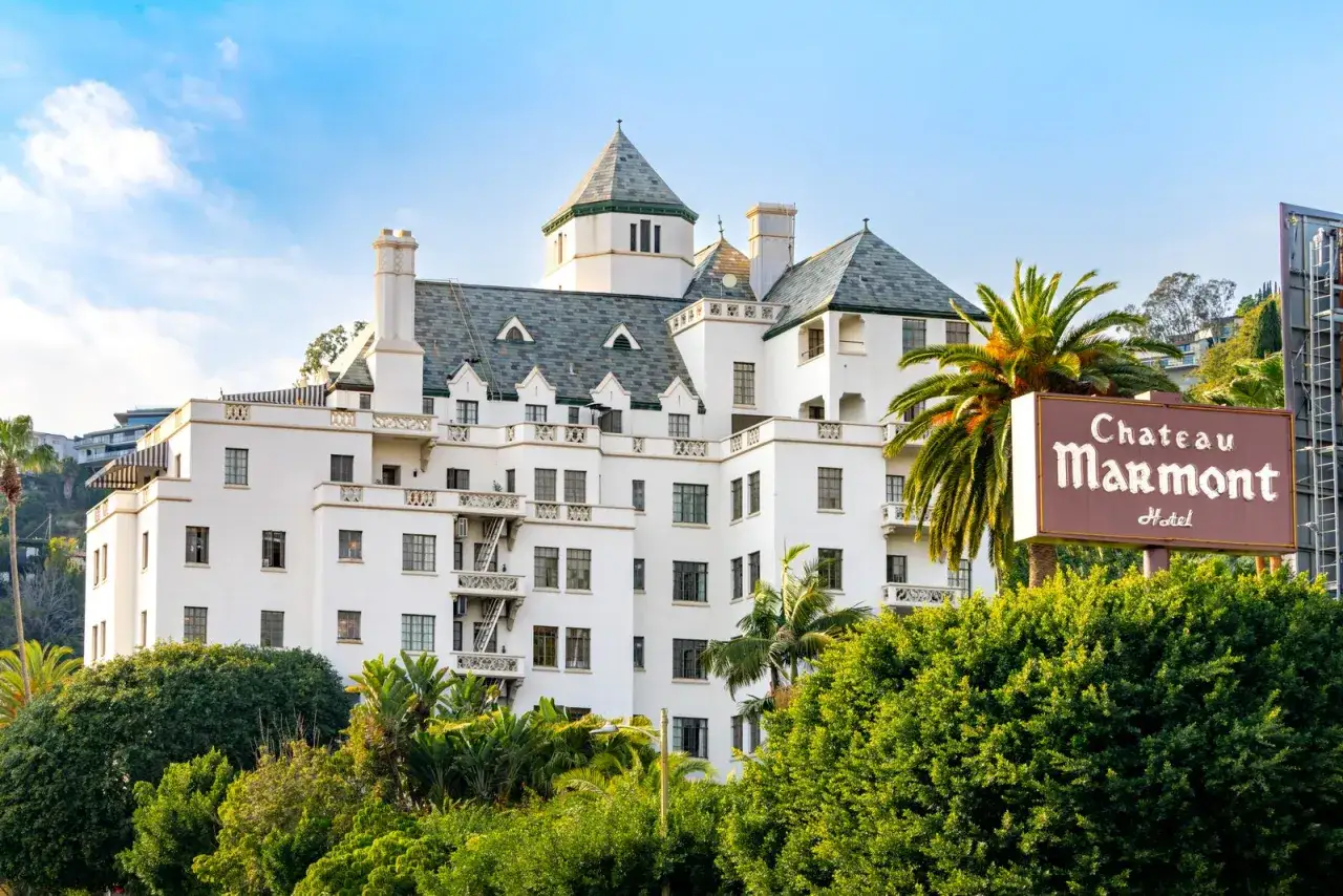 Chateau Marmont, gdzie mieszka Keanu Reeves, to biały hotel z zielonym dachem i palmami.
