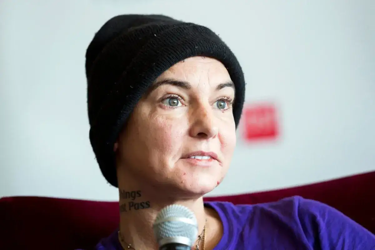 Sinead O'Connor w czarnej czapce, z tatuażem na szyi 