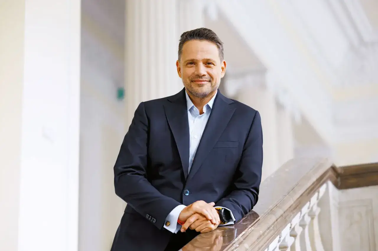 Rafał Trzaskowski, prezydent Warszawy, w eleganckim garniturze. Ile lat ma Trzaskowski? Wiek to tylko liczba, gdy patrzy się na jego energię.