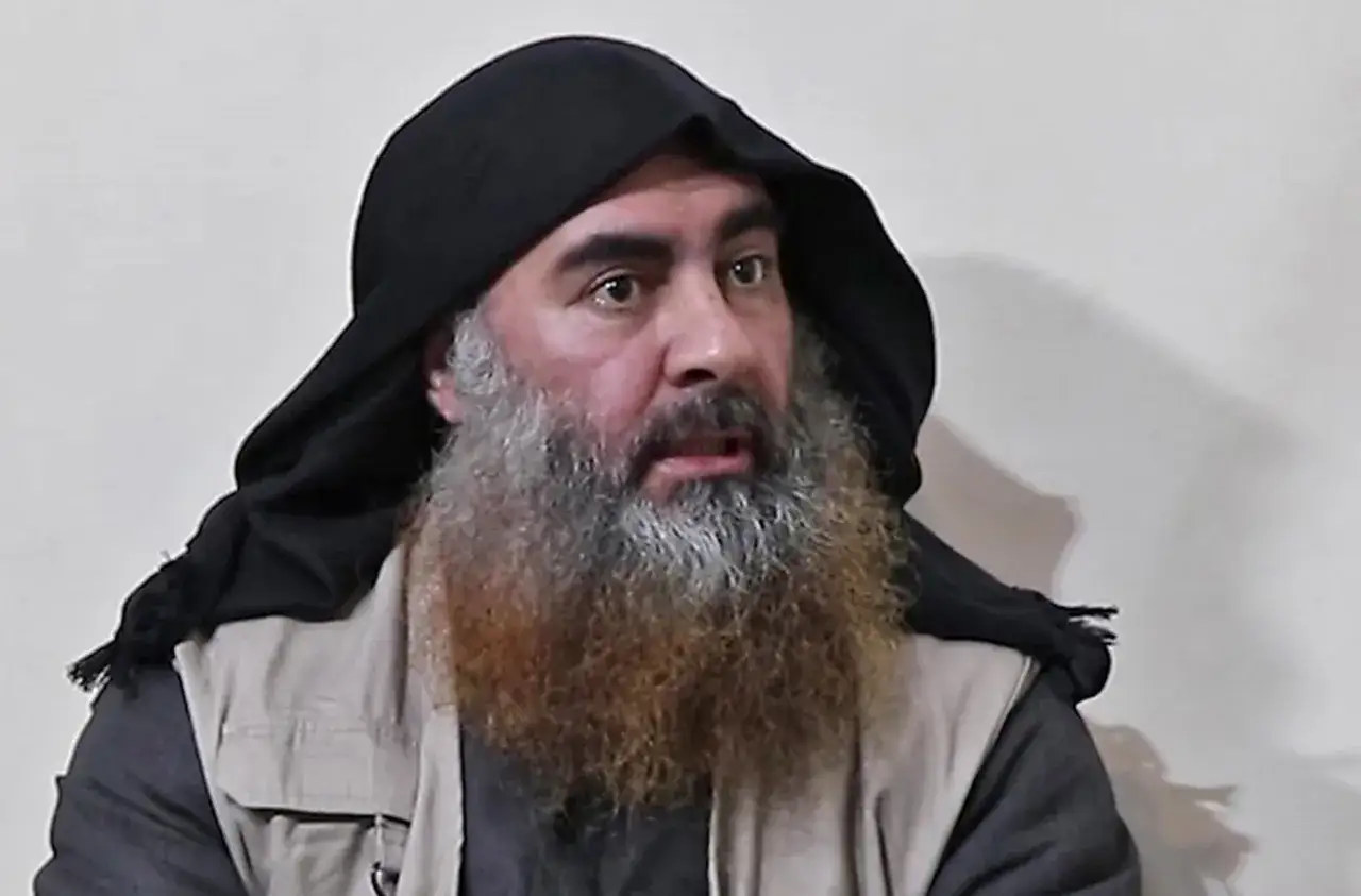 Mężczyzna z długą, siwą brodą i czarnym nakryciem głowy, przypominający Abu Bakra al-Baghdadiego, patrzy w bok.