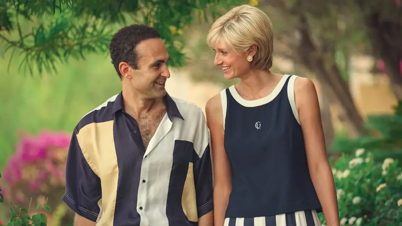 Dodi Al Fayed i księżna Diana uśmiechają się do siebie, spacerując wśród zieleni.