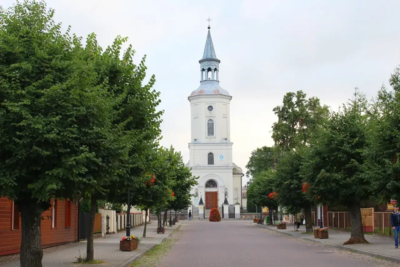 Ulica prowadząca do kościoła, otoczona drzewami. Czuje się tu spokój, jakby było się u Pana Boga w ogródku.