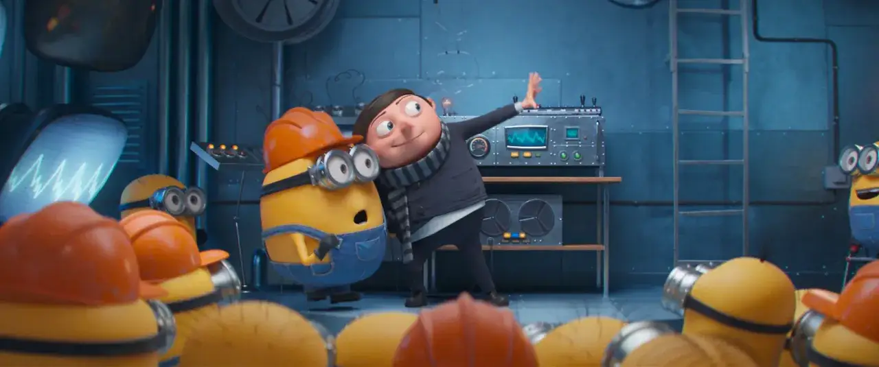 Minionki wejście Gru do laboratorium. Jeden minionek w kasku i ogrodniczkach, Gru w szaliku, obok maszyna z ekranem.