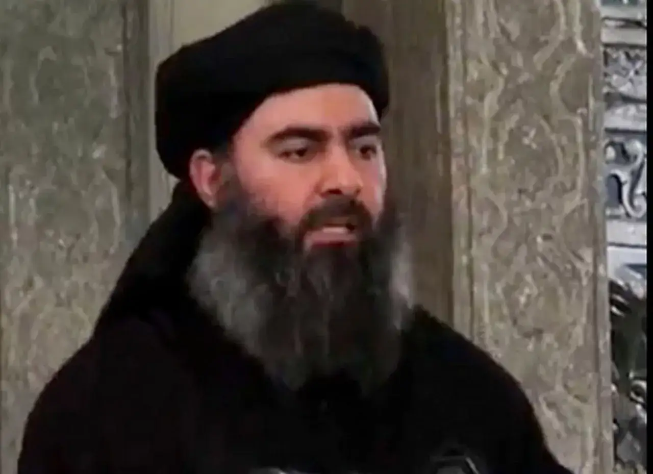Mężczyzna z brodą i czarnym turbanem, przypominający Abu Bakra al-Baghdadiego, przemawia w meczecie.